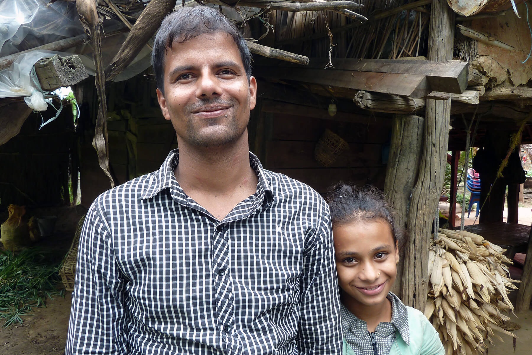 Dhruba stands with his niece Sabita out the front of their home in Chitwan