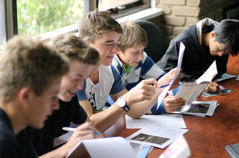 Melbourne Grammar students looking at their writings at The Leprosy Mission Australia office